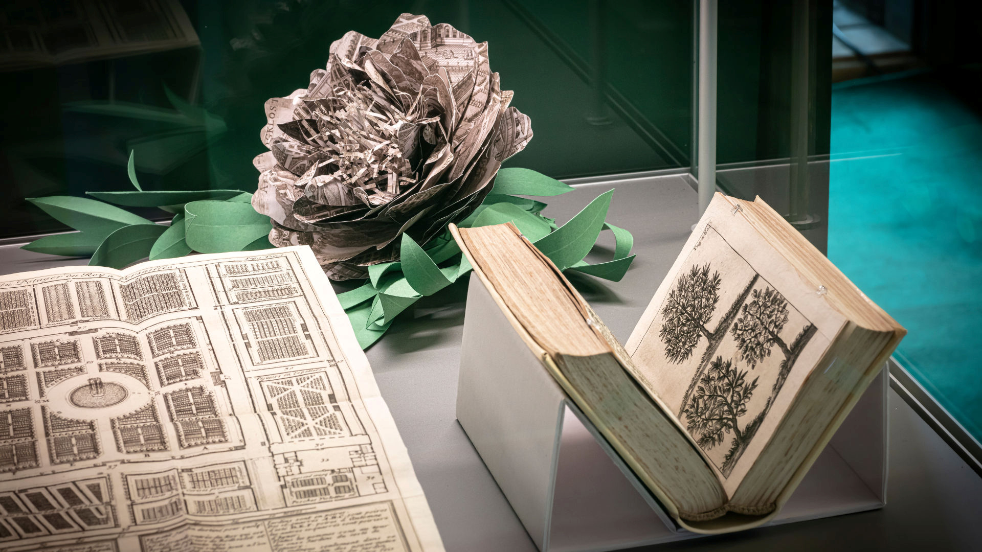 Book, drawing and paper flower in a stand.