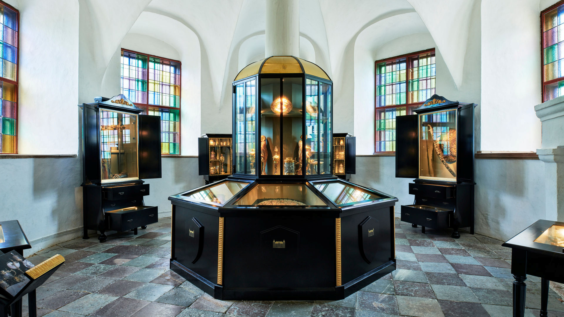 An octagonal room with showcases in black and gold.