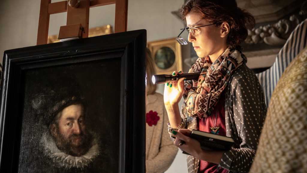 A conservator looks at a work of art from the Skokloster Castle collection.