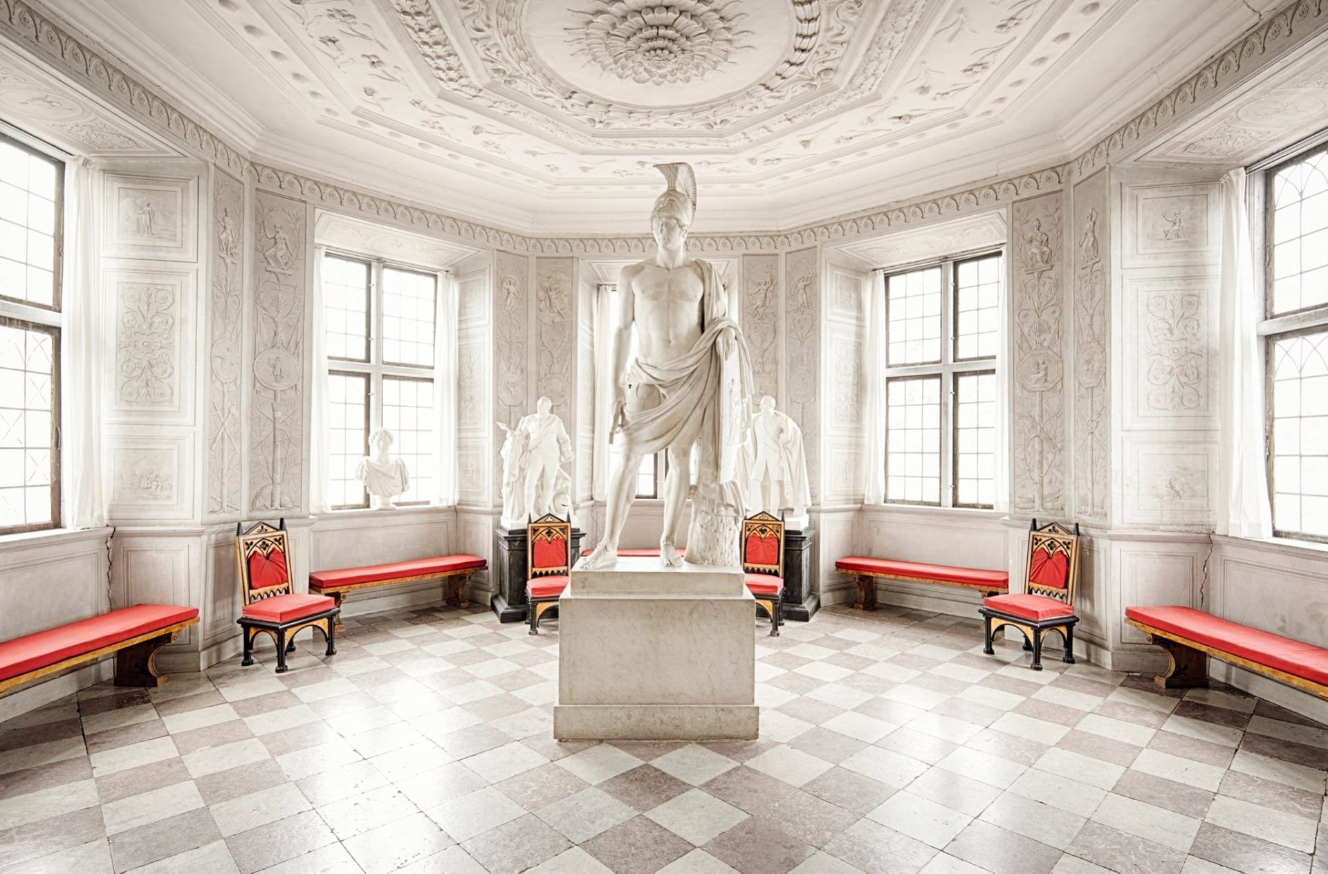 Interiör i slottet där flera statyer visas.