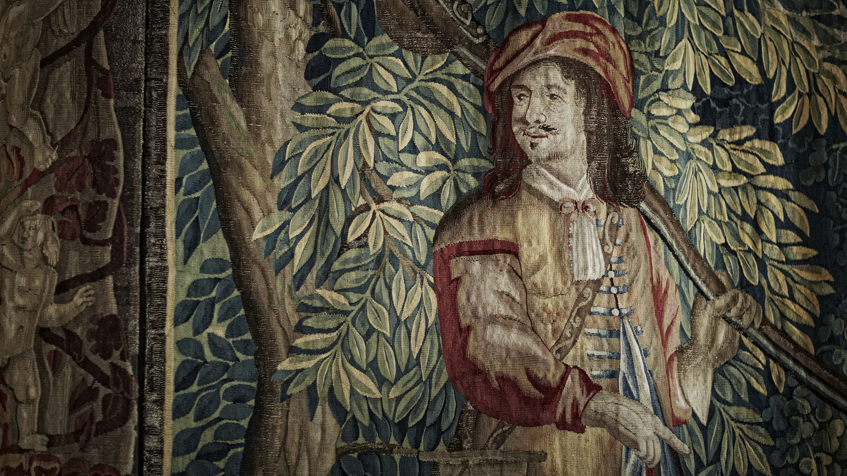 Detail of a tapestry showing a man in front of a tree.