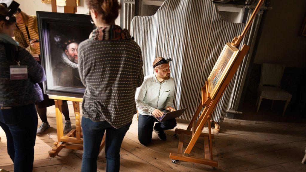 A conservator looks at a work of art from the Skokloster Castle collection.