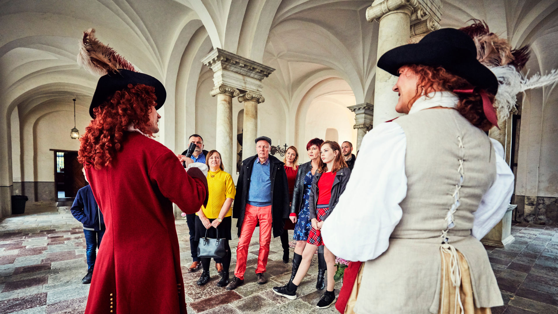  Two guides give a tour for a group in the castle's entrance floor.