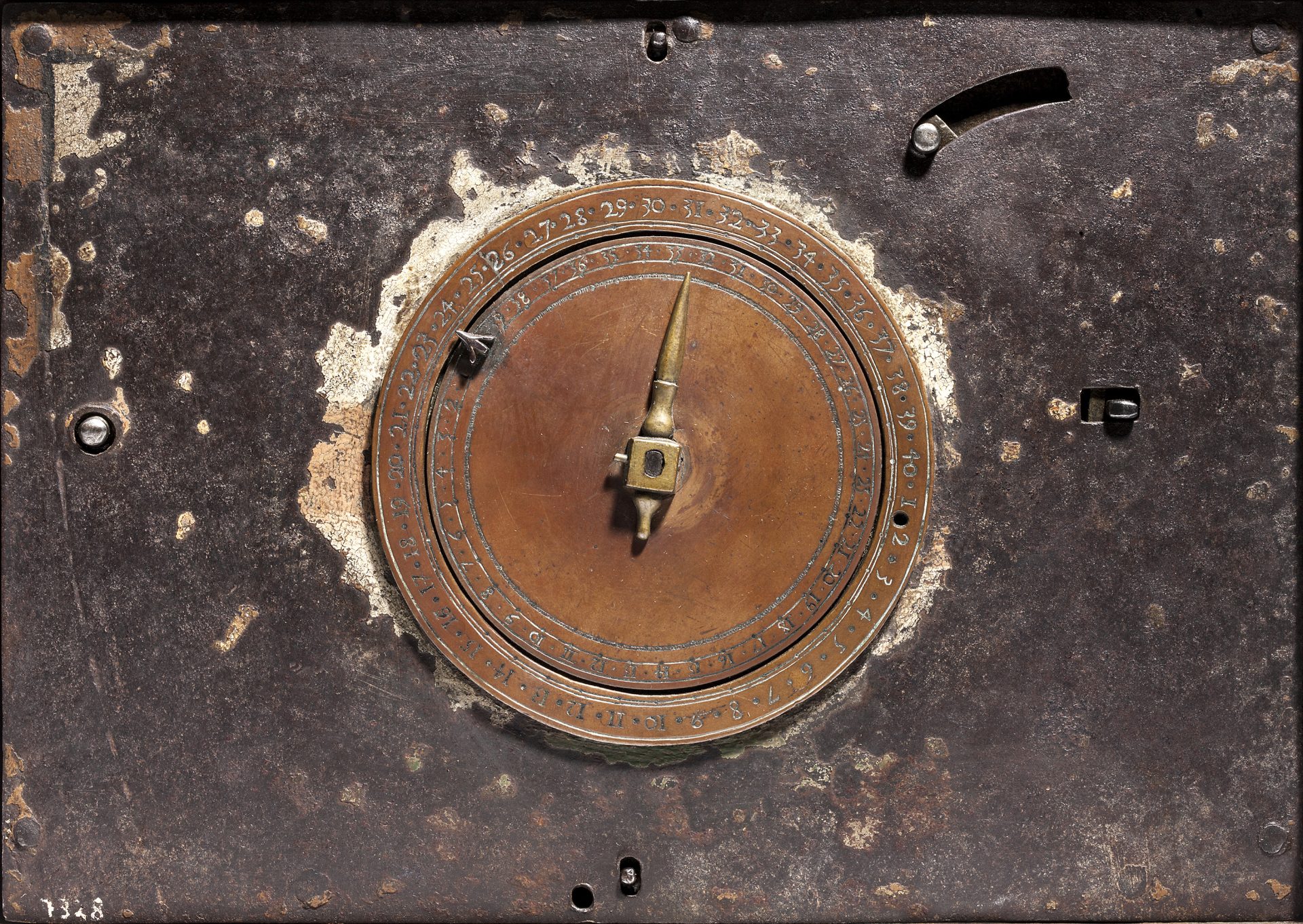 A copper clock-face on a metal background.