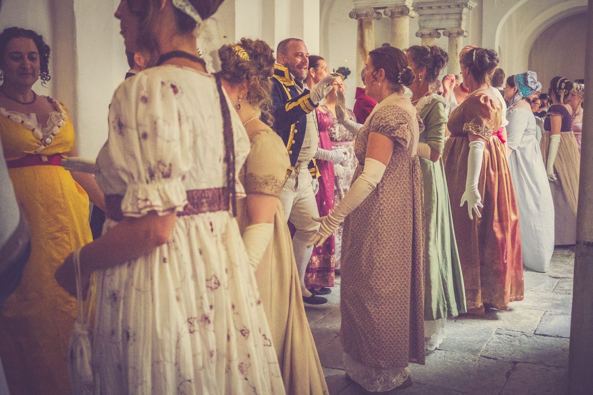 Ball guests dance wearing historical clothing.