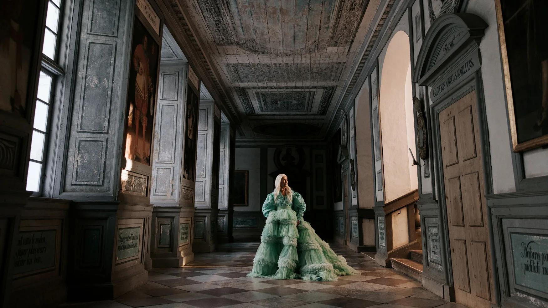 A model dressed in a dress by Louise Xin stands and poses on one of the floors of Skokloster Castle.