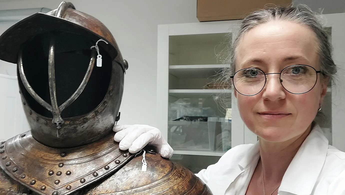 Självporträtt av konservator Christina Tegnér med en rustning
