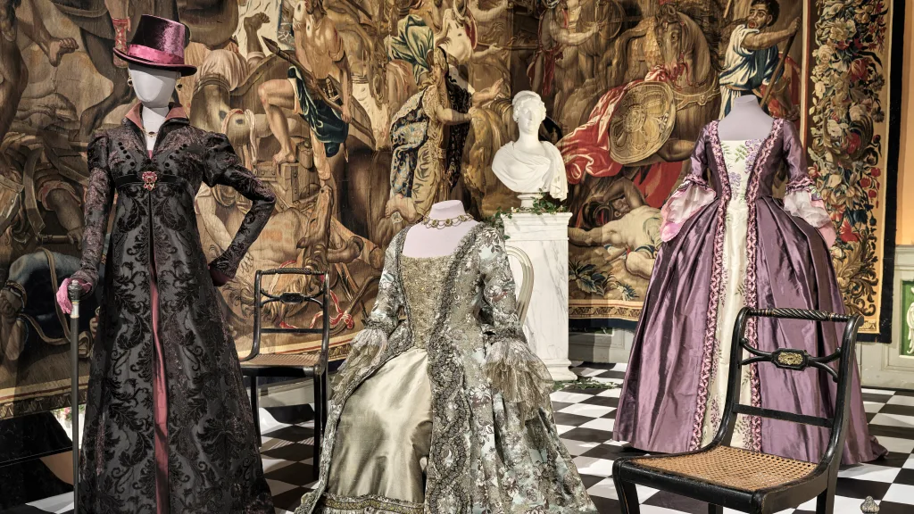 Dresses in a castle environment with a tapestry in the background
